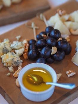 Artistic cheese board featuring berries, nuts, and honey for a delicious appetizer.